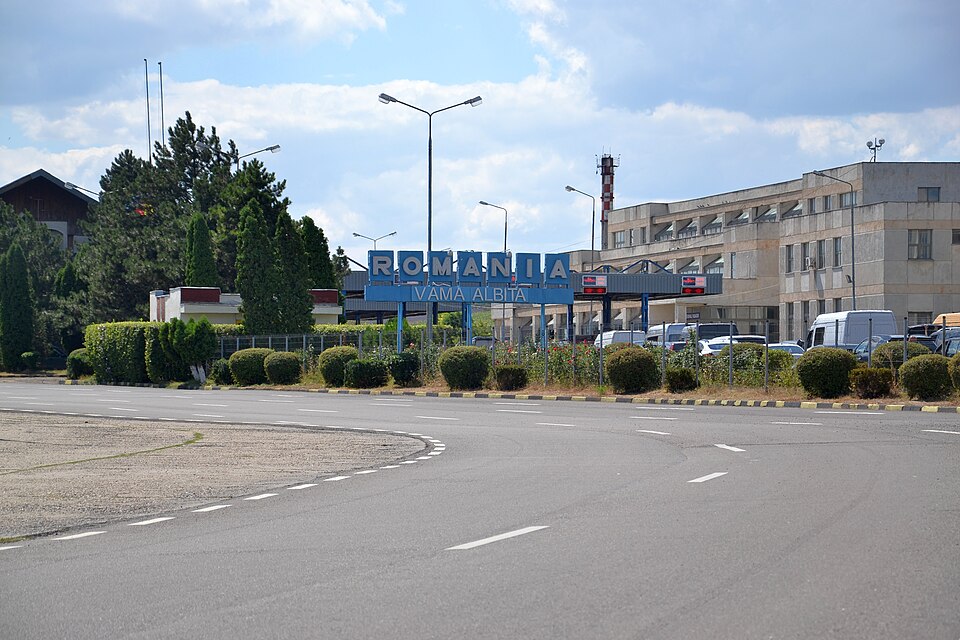 Punctul de trecere a frontierei Albița, cu panoul albastru cu inscripțiile Romania și Vama Albita deasupra drumului și clădirea vămii în dreapta